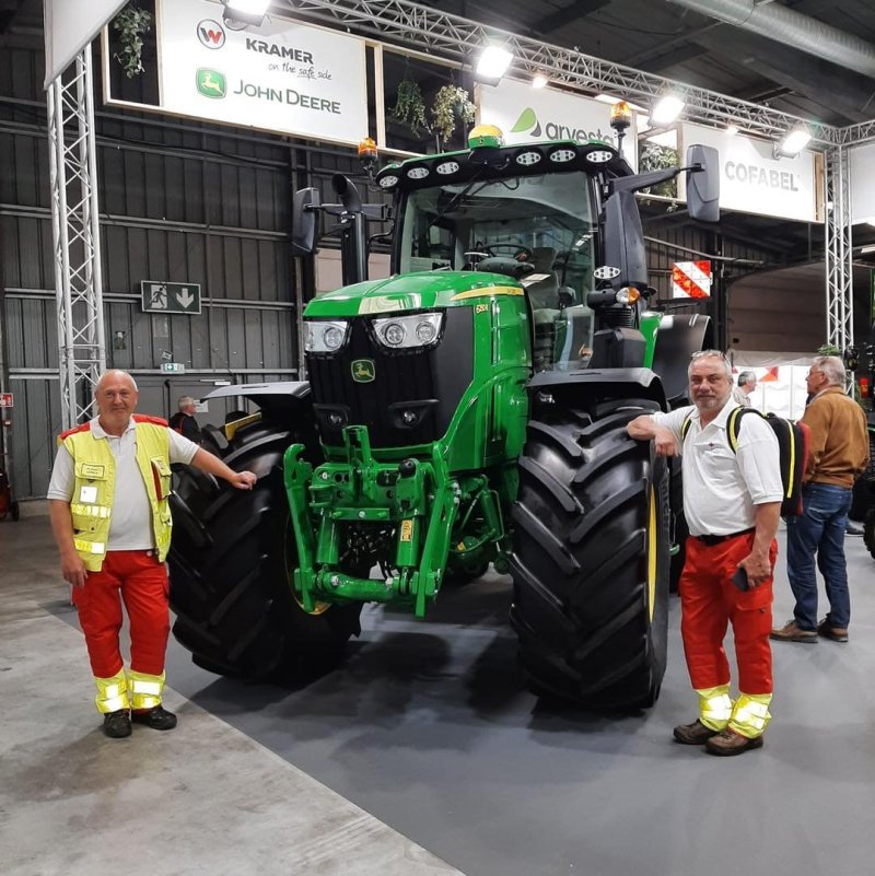Onze hulpdienstvrijwilligers op de foto met de grote tractoren aanwezig op de beurs.