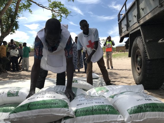 Rode Kruisvrijwilligers delen meel uit in een afgelegen dorp in Zambia.