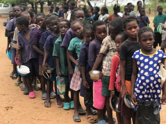 Kinderen staan in de rij tijdens een voedselbedeling in Zambia. Vaak is het al 2 à 3 dagen geleden dat ze nog eten kregen.